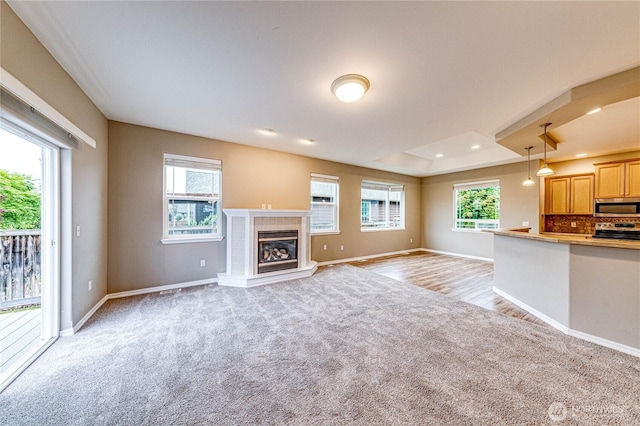 120 Petal Ln, Sequim, WA 98382 - unfurnished living room with light carpet, a tiled fireplace, a tray ceiling, and recessed lighting