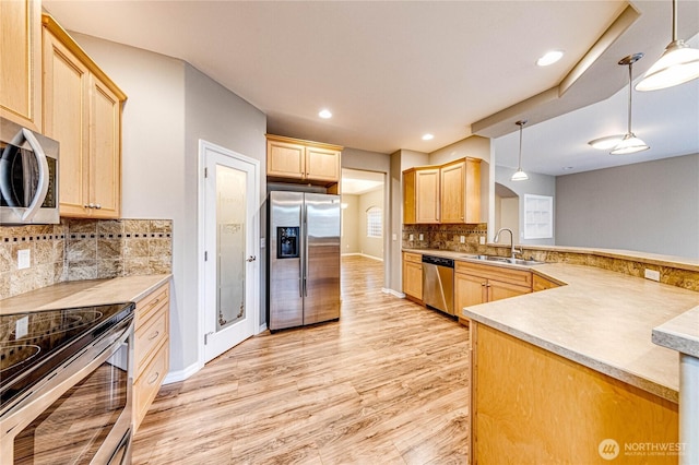 120 Petal Ln, Sequim, WA 98382 - kitchen with appliances with stainless steel finishes, light brown cabinets, light wood-type flooring, a peninsula, and backsplash