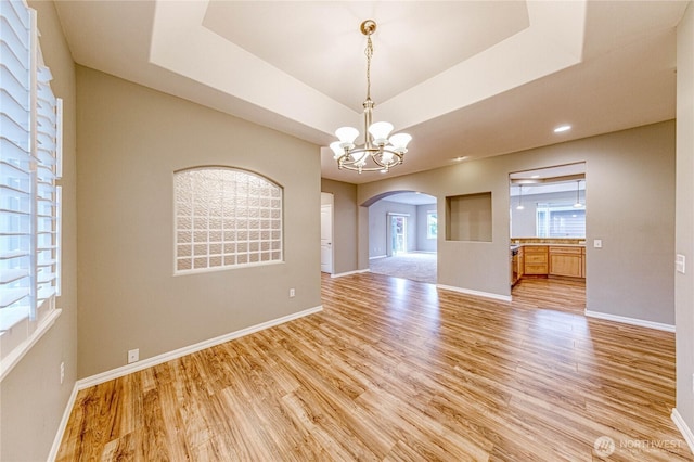 120 Petal Ln, Sequim, WA 98382 - empty room featuring arched walkways, light wood-style floors, a chandelier, and a raised ceiling