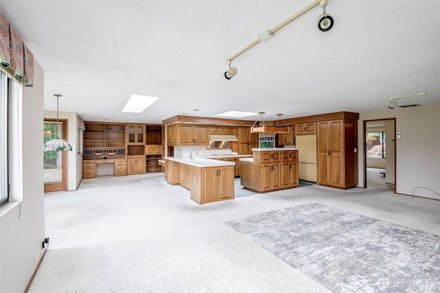 3524 SW 325th St, Federal Way, WA 98023 - kitchen with freestanding refrigerator, a skylight, rail lighting, light countertops, and brown cabinetry