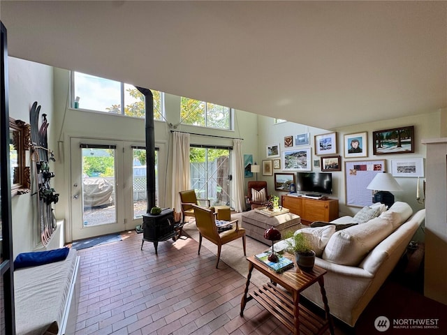 716 N 42nd St, Seattle, WA 98103 - living room with a wood stove, brick floors, high vaulted ceiling, and french doors