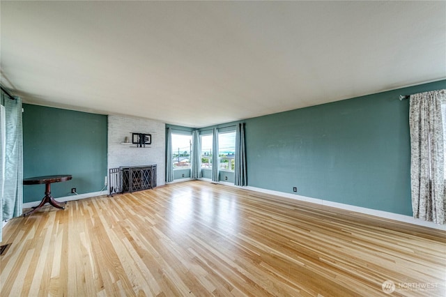 727 E 11th St, Port Angeles, WA 98362 - unfurnished living room featuring wood finished floors and a large fireplace