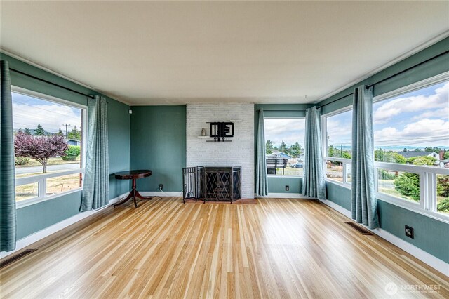 727 E 11th St, Port Angeles, WA 98362 - unfurnished living room with wood finished floors, plenty of natural light, and a stone fireplace