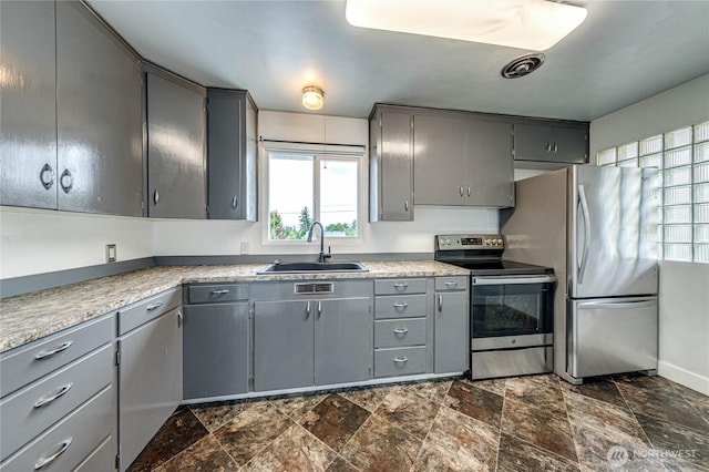 727 E 11th St, Port Angeles, WA 98362 - kitchen with stainless steel appliances, gray cabinetry, stone finish flooring, and light countertops