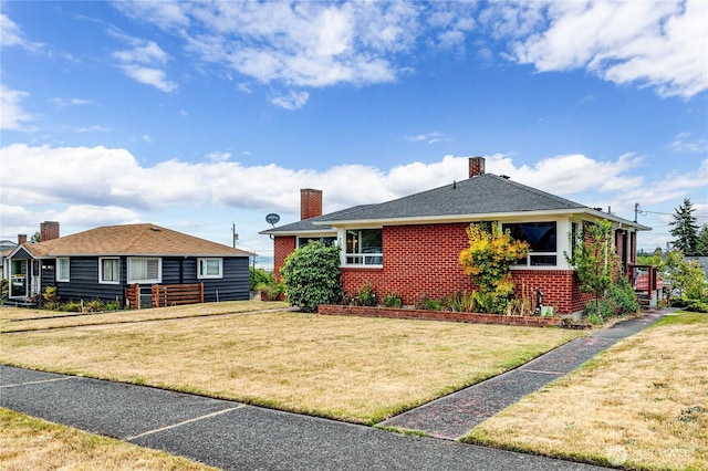 727 E 11th St, Port Angeles, WA 98362 - view of front of home with brick siding, a chimney, and a front yard