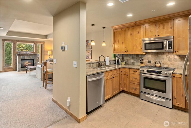 3770 Suncadia Trl Unit 309, Cle Elum, WA 98922 - kitchen featuring stainless steel appliances, light stone countertops, a premium fireplace, tasteful backsplash, and recessed lighting