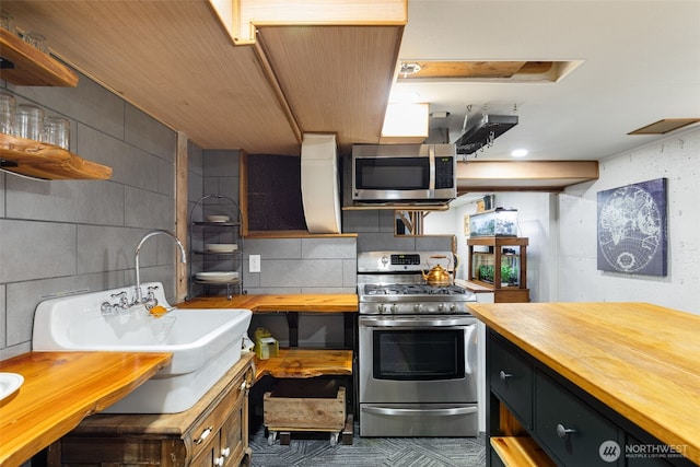 11803 14th Ave S, Seattle, WA 98168 - kitchen featuring butcher block countertops, appliances with stainless steel finishes, open shelves, dark cabinetry, and tasteful backsplash