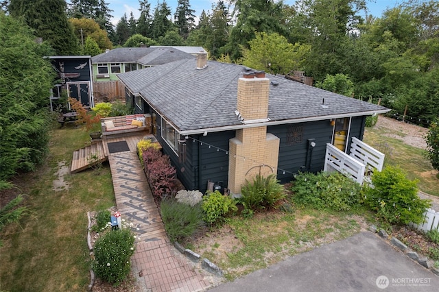 11803 14th Ave S, Seattle, WA 98168 - view of side of home featuring a chimney, a wooden deck, and a shingled roof