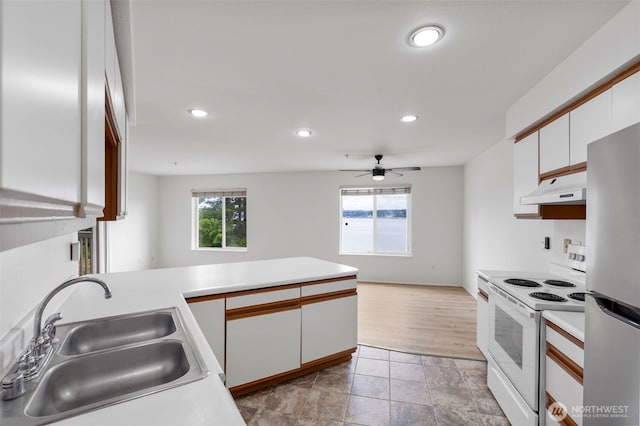 2255 Highview Ln W Unit D101, Bremerton, WA 98312 - kitchen featuring white electric range, under cabinet range hood, freestanding refrigerator, white cabinetry, and recessed lighting