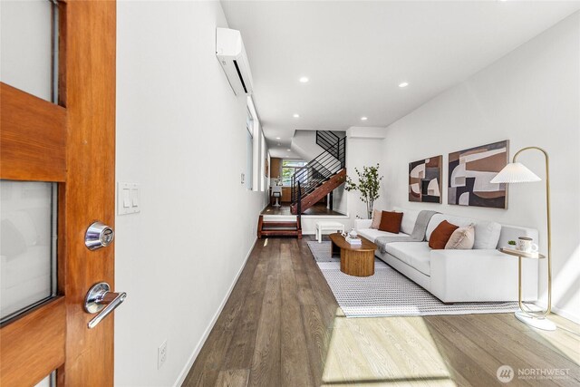 2224 NW 62nd St Unit C, Seattle, WA 98107 - living room with a wall unit AC, wood finished floors, stairs, and recessed lighting