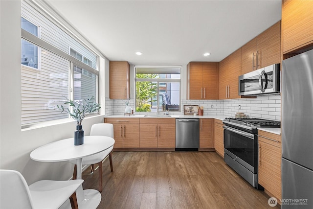 2224 NW 62nd St Unit C, Seattle, WA 98107 - kitchen featuring appliances with stainless steel finishes, light countertops, dark wood-type flooring, decorative backsplash, and recessed lighting