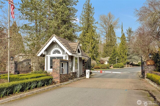20821 NE 141st St, Woodinville, WA 98077 - view of asphalt road featuring a gate, street lighting, and traffic signs