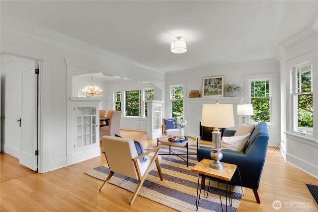 1523 4th Ave N, Seattle, WA 98109 - living area featuring a chandelier, light wood finished floors, plenty of natural light, and ornamental molding