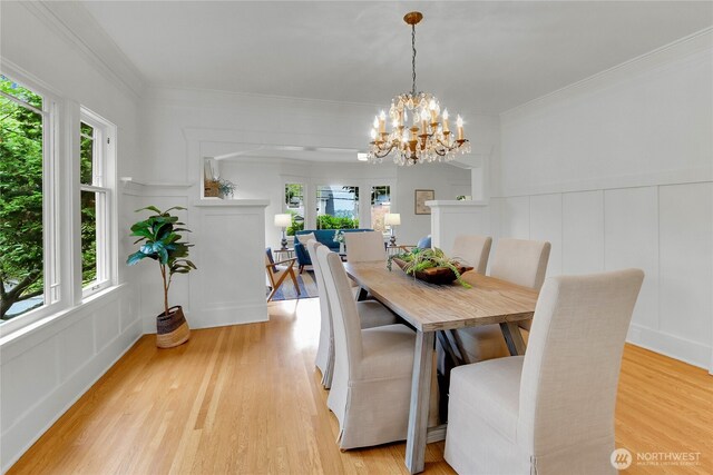 1523 4th Ave N, Seattle, WA 98109 - dining area with a decorative wall, plenty of natural light, light wood-style flooring, a chandelier, and ornamental molding