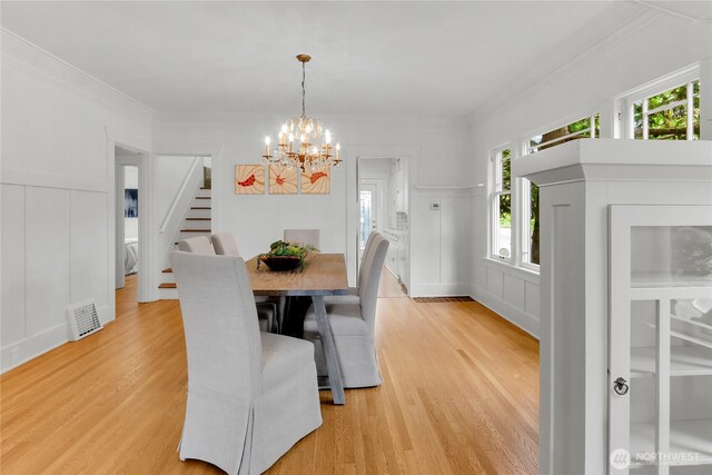 1523 4th Ave N, Seattle, WA 98109 - dining space featuring a decorative wall, stairway, a chandelier, healthy amount of natural light, and light wood-style floors