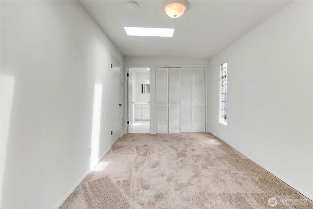 1523 4th Ave N, Seattle, WA 98109 - unfurnished bedroom featuring carpet floors, a skylight, a closet, and connected bathroom