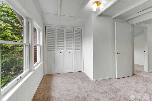 1523 4th Ave N, Seattle, WA 98109 - unfurnished bedroom with beam ceiling, carpet, and a closet