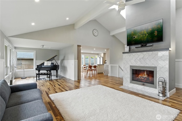 2500 171st Ave SE, Bellevue, WA 98008 - living room featuring wood finished floors, beam ceiling, ceiling fan, a tile fireplace, and high vaulted ceiling