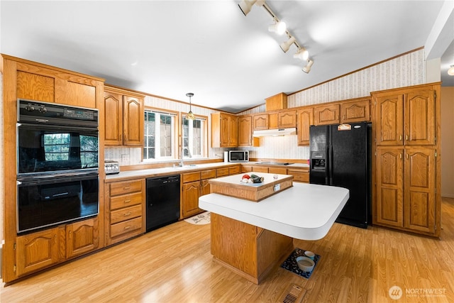 301 Salmonberry Ln, Friday Harbor, WA 98250 - kitchen with black appliances, wallpapered walls, light countertops, lofted ceiling, and under cabinet range hood