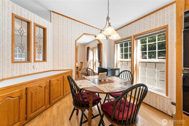 301 Salmonberry Ln, Friday Harbor, WA 98250 - dining area featuring wallpapered walls, light wood finished floors, ornamental molding, and arched walkways