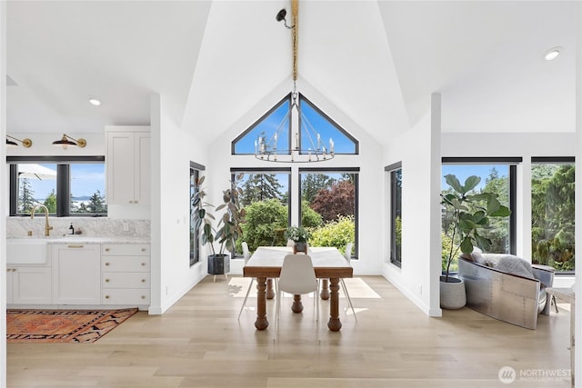 405 Bayside Rd, Bellingham, WA 98225 - dining room featuring healthy amount of natural light, light wood-type flooring, a chandelier, high vaulted ceiling, and beam ceiling