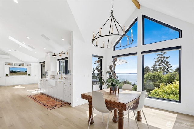 405 Bayside Rd, Bellingham, WA 98225 - dining room featuring a chandelier, high vaulted ceiling, plenty of natural light, light wood-style floors, and beam ceiling