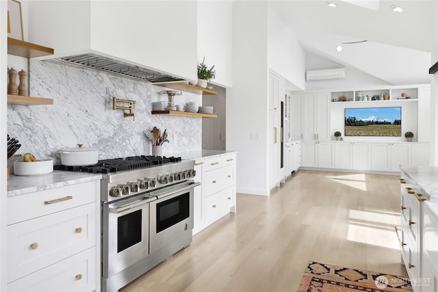 405 Bayside Rd, Bellingham, WA 98225 - kitchen featuring open shelves, range with two ovens, custom exhaust hood, an AC wall unit, and light stone counters