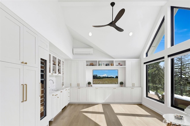 405 Bayside Rd, Bellingham, WA 98225 - unfurnished living room with a wall mounted air conditioner, light wood-style floors, high vaulted ceiling, recessed lighting, and a ceiling fan