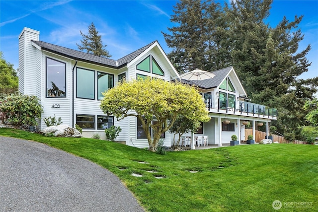 405 Bayside Rd, Bellingham, WA 98225 - view of front of house with a chimney, a front yard, a shingled roof, and a patio area