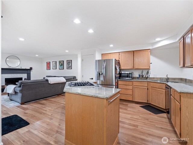 8221 122nd Ave NE, Kirkland, WA 98033 - kitchen with stainless steel appliances, light wood-type flooring, a kitchen island, light stone countertops, and open floor plan
