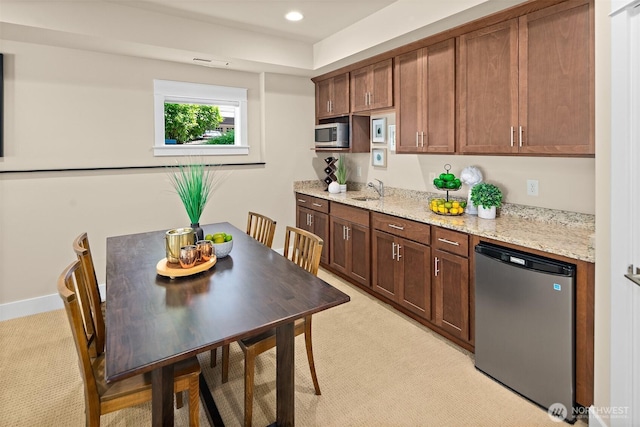 2507 101st Ln NE, Bellevue, WA 98004 - kitchen with fridge, stainless steel microwave, light carpet, light stone countertops, and recessed lighting