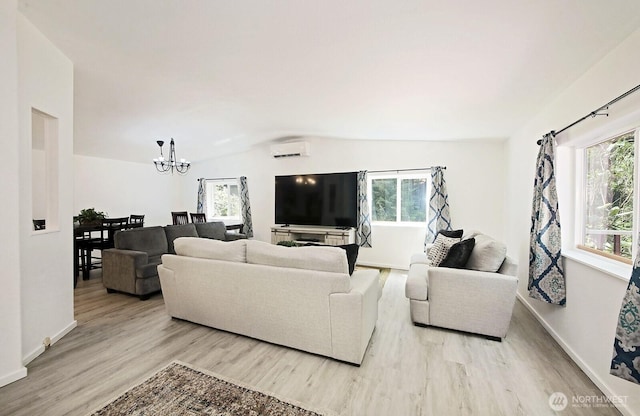5845 Alpha Ln, Freeland, WA 98249 - living area with a wall unit AC, light wood-style floors, a chandelier, healthy amount of natural light, and vaulted ceiling