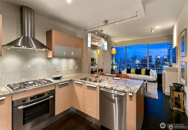 737 Olive Way Unit 3606, Seattle, WA 98101 - kitchen featuring wall chimney exhaust hood, stainless steel appliances, a peninsula, open floor plan, and dark wood-style floors