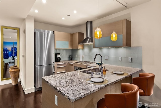737 Olive Way Unit 3606, Seattle, WA 98101 - kitchen with a peninsula, appliances with stainless steel finishes, light stone countertops, wall chimney exhaust hood, and dark wood-type flooring