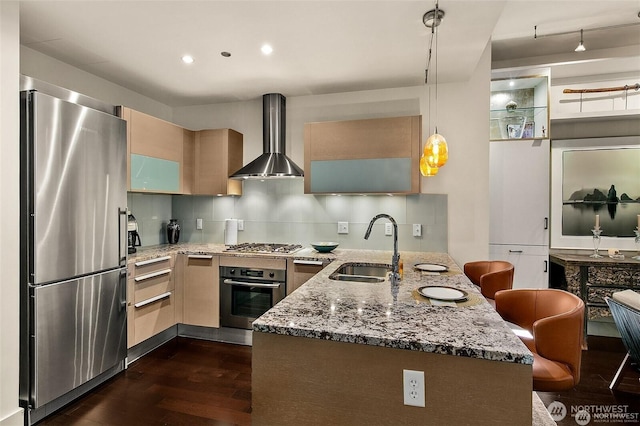 737 Olive Way Unit 3606, Seattle, WA 98101 - kitchen featuring appliances with stainless steel finishes, a peninsula, wall chimney range hood, dark wood finished floors, and light stone counters