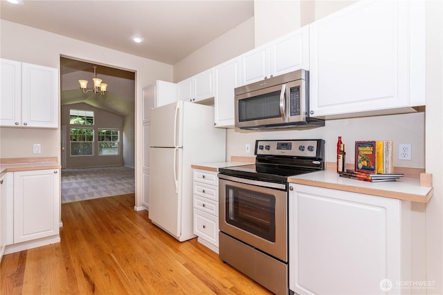 23302 53rd Ave S Unit 4-1, Kent, WA 98032 - kitchen featuring stainless steel appliances, light wood-style flooring, vaulted ceiling, white cabinets, and a chandelier