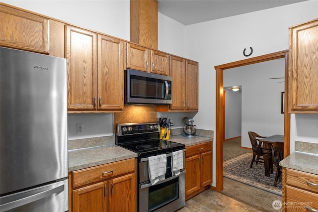 6137 189th Loop SW, Rochester, WA 98579 - kitchen with stainless steel appliances, brown cabinetry, and light countertops