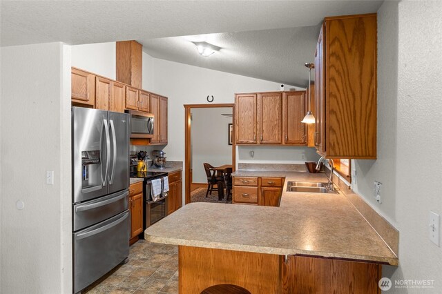 6137 189th Loop SW, Rochester, WA 98579 - kitchen featuring stainless steel appliances, a peninsula, lofted ceiling, brown cabinetry, and light countertops
