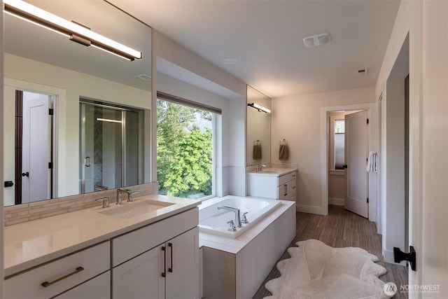 2035 S Fruitland, Puyallup, WA 98371 - full bathroom with a garden tub, two vanities, a shower stall, and wood finished floors