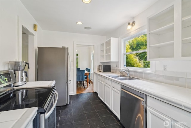2726 34th Ave S, Seattle, WA 98144 - kitchen with stainless steel appliances, open shelves, white cabinetry, tile counters, and recessed lighting