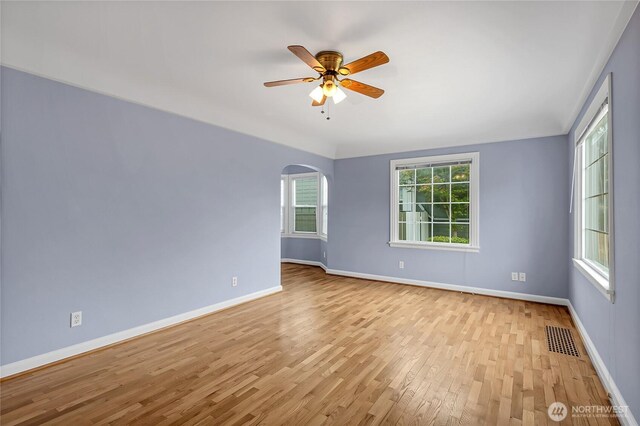 4015 N 13th St, Tacoma, WA 98406 - empty room featuring light wood finished floors, arched walkways, and a ceiling fan