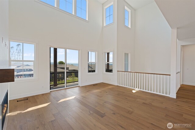 382 W Fir Loop, Washougal, WA 98671 - unfurnished living room featuring a towering ceiling, wood-type flooring, and a fireplace