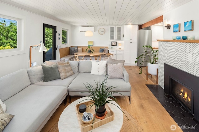 10426 SW 112th St, Vashon, WA 98070 - living room with a wall mounted air conditioner, a tiled fireplace, light wood-style flooring, and wood ceiling