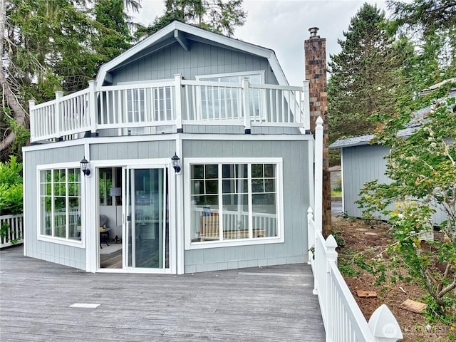 81 E Panorama Way, Grapeview, WA 98546 - back of property with a balcony, a chimney, a wooden deck, and a gambrel roof