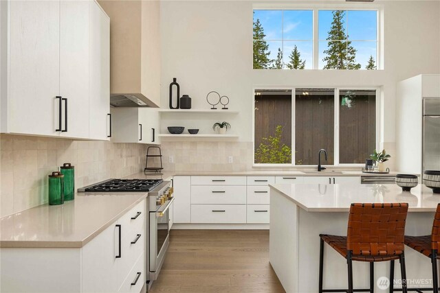 1950 Wanawish Loop, Cle Elum, WA 98922 - kitchen with range with gas stovetop, wall chimney range hood, light countertops, and white cabinetry
