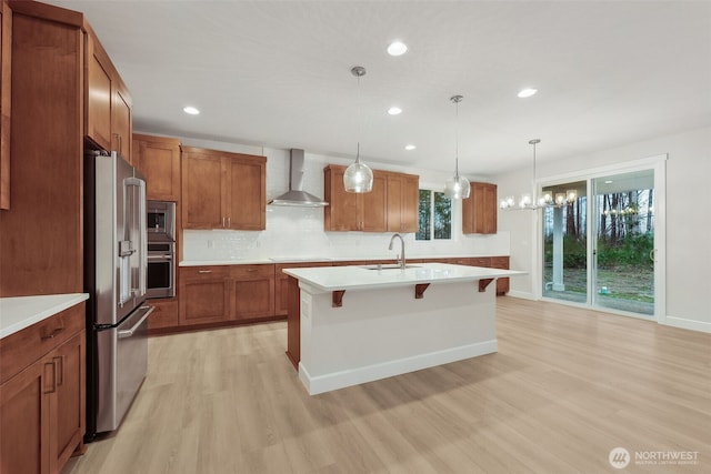 13600 100th St NE Unit 212, Lake Stevens, WA 98258 - kitchen featuring stainless steel appliances, wall chimney exhaust hood, light wood-style floors, brown cabinetry, and light countertops