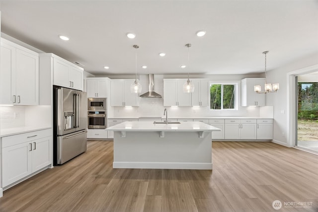 13600 100th St NE Unit 212, Lake Stevens, WA 98258 - kitchen with appliances with stainless steel finishes, wall chimney range hood, decorative backsplash, light wood-style floors, and recessed lighting