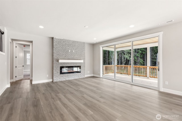13600 100th St NE Unit 212, Lake Stevens, WA 98258 - unfurnished living room featuring wood finished floors, a stone fireplace, and recessed lighting