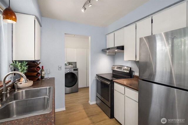 15484 174th Ave SE, Monroe, WA 98272 - kitchen with appliances with stainless steel finishes, washer / clothes dryer, under cabinet range hood, dark countertops, and light wood-style floors