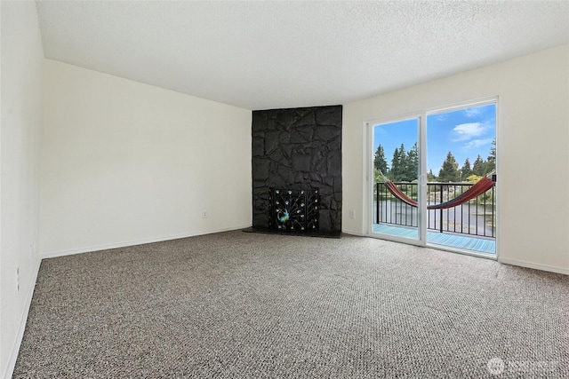 615 75th St SE Unit C43, Everett, WA 98203 - unfurnished living room with carpet flooring, a fireplace, and a textured ceiling